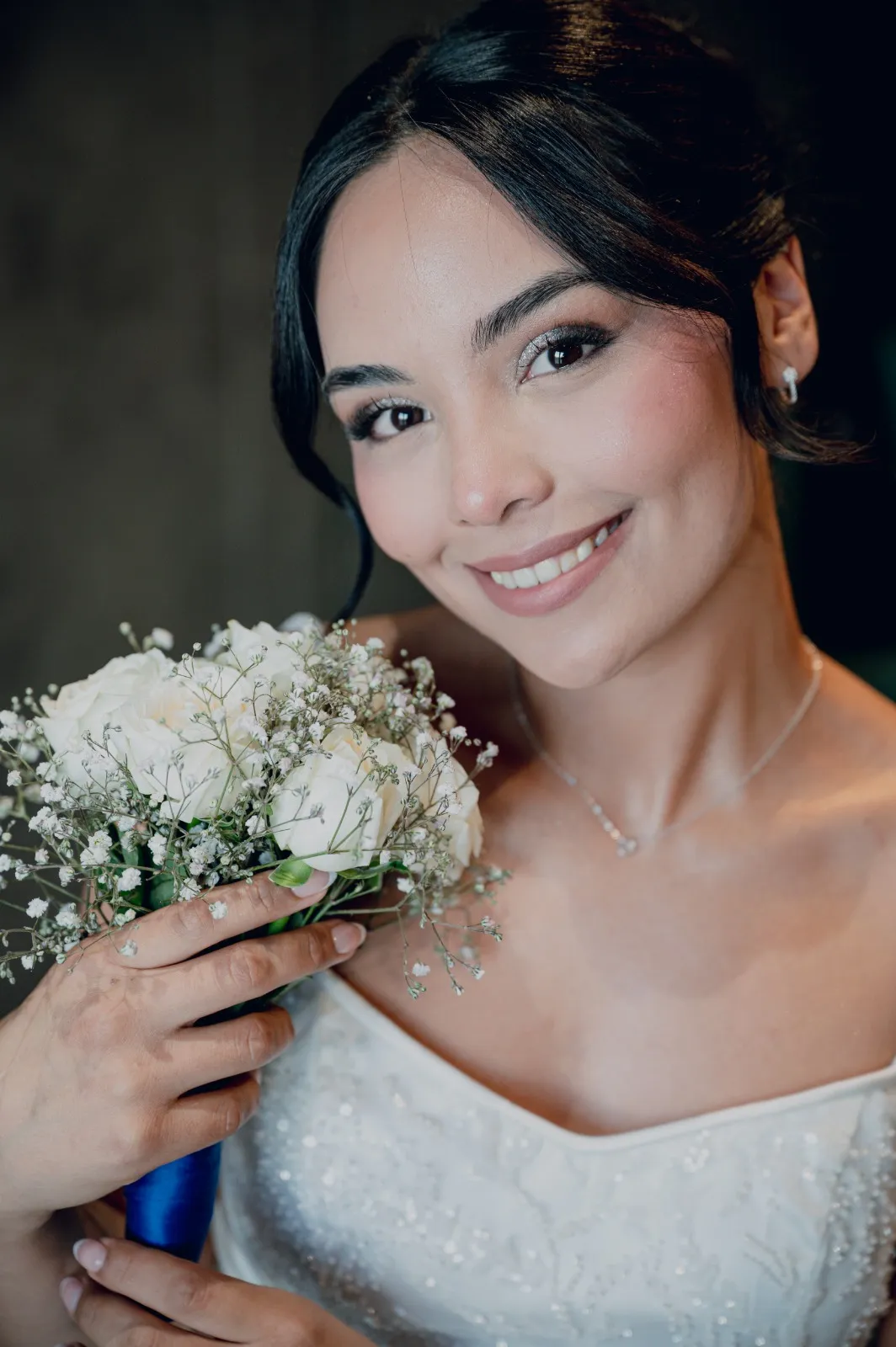 Novia sonriendo con su ramo de flores blancas