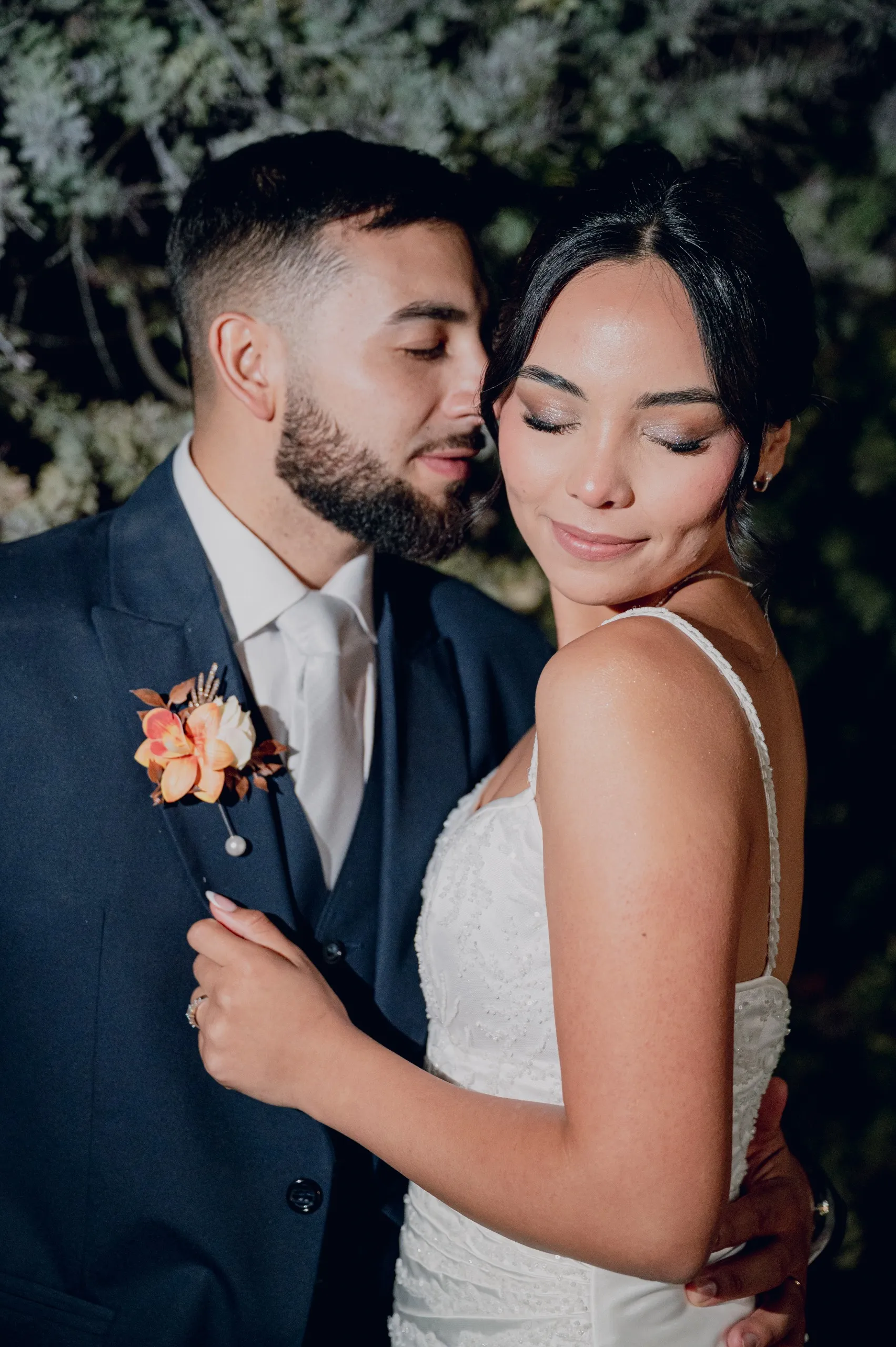 Novios abrazados con los ojos cerrados, retrato cercano