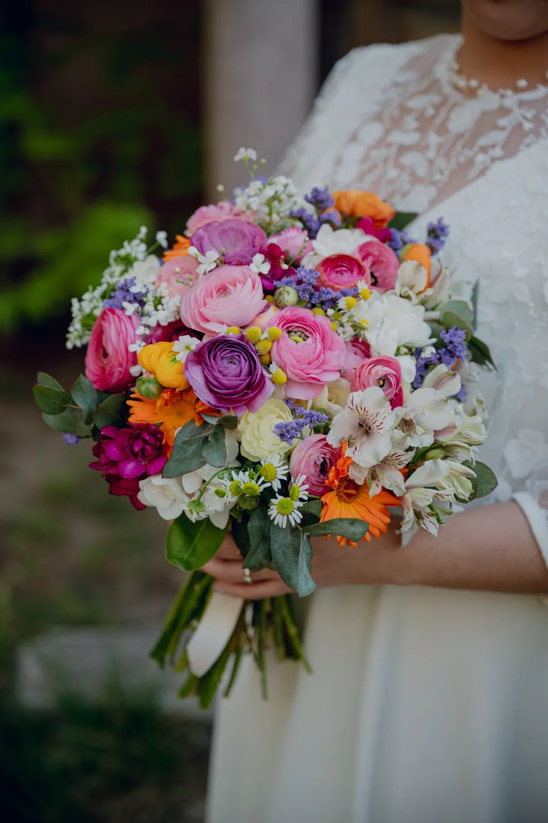 Detalle del ramo de flores de colores en manos de la novia